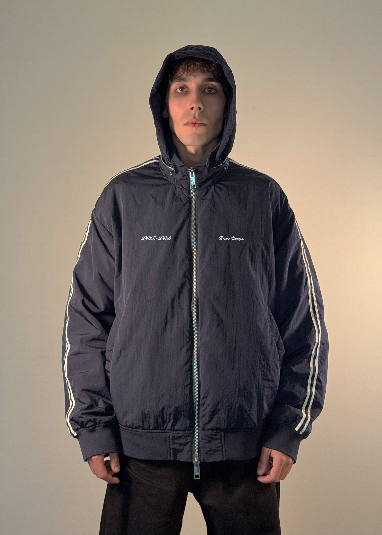 "Men's black track jacket with white stripe sleeves, front zip closure, and embroidered 'SHME-SHNO' and 'Bence Varga' branding – stylish streetwear outerwear for casual fashion."