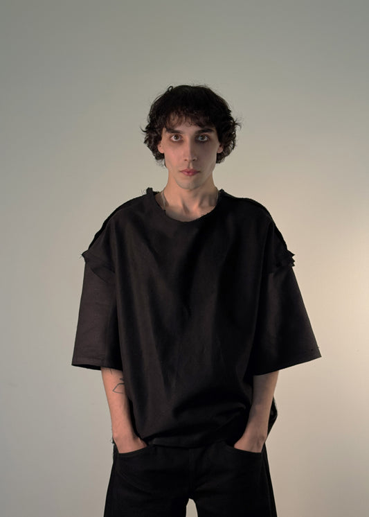 ORIGINAL T-Shirt, Shme-Shno, Hungarian brand, Budapest-founded, handcrafted in Toronto, unisex black oversized shirt, avant-garde fashion, minimalist streetwear, heavyweight premium cotton, sculptural silhouette, raw seams, hand-finished edges, Varrni stitching technique, artisanal craftsmanship, contemporary brutalist aesthetics, cultural heritage meets modern design, limited edition, luxury streetwear, heritage-inspired fashion.

