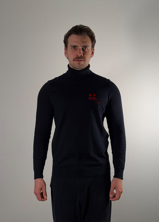 Black turtleneck sweater by Shme-Shno featuring a bold red "EVIL" graphic across the chest and minimalist geometric accents. Made from ultra-soft knit fabric with a sleek, slim fit and classic turtleneck collar. Hand-sewn using the Hungarian varrni technique for artisanal quality and durability. A fashion-forward piece blending contemporary style with avant-garde design.