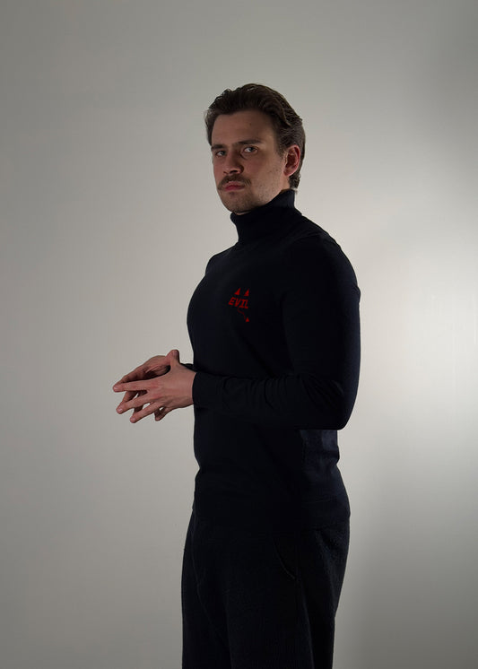 Black turtleneck sweater by Shme-Shno featuring a bold red "EVIL" graphic across the chest and minimalist geometric accents. Made from ultra-soft knit fabric with a sleek, slim fit and classic turtleneck collar. Hand-sewn using the Hungarian varrni technique for artisanal quality and durability. A fashion-forward piece blending contemporary style with avant-garde design.