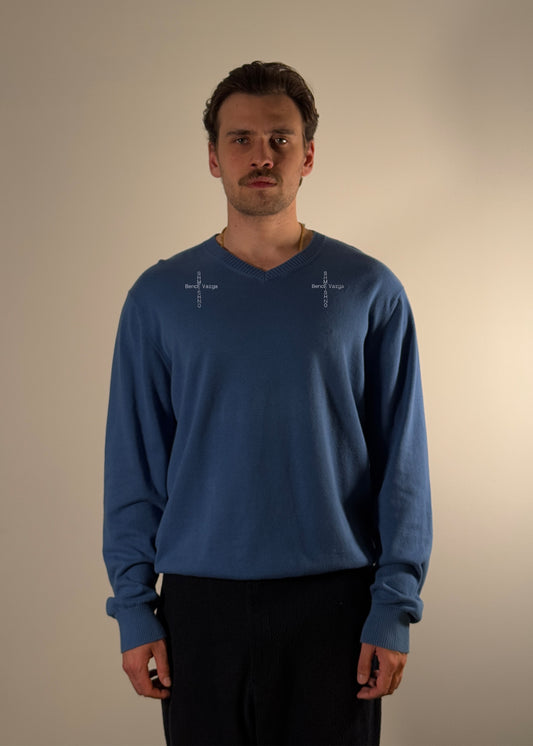 Shme-Shno SHOVNO Sweater in blue, featuring embroidered cross motifs symbolizing the connection between Shme-Shno and Bence Varga. Designed by Hungarian brand Shme-Shno founded in Budapest and crafted in Canada using traditional Hungarian Varrni stitching technique. Soft cotton-blend fabric with V-neck silhouette and ribbed cuffs.