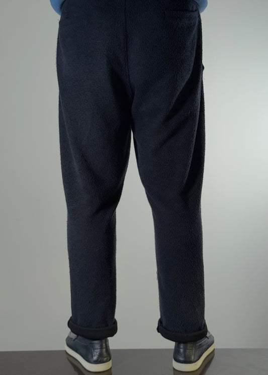 Shme-Shno Brianche Pants in deep navy, designed by Hungarian fashion brand Shme-Shno founded in Budapest and crafted in Canada. Made with soft fleece-textured fabric and featuring heritage Hungarian Varrni stitching technique. Tailored fit with cuffed hems, blending comfort, tradition, and contemporary style.